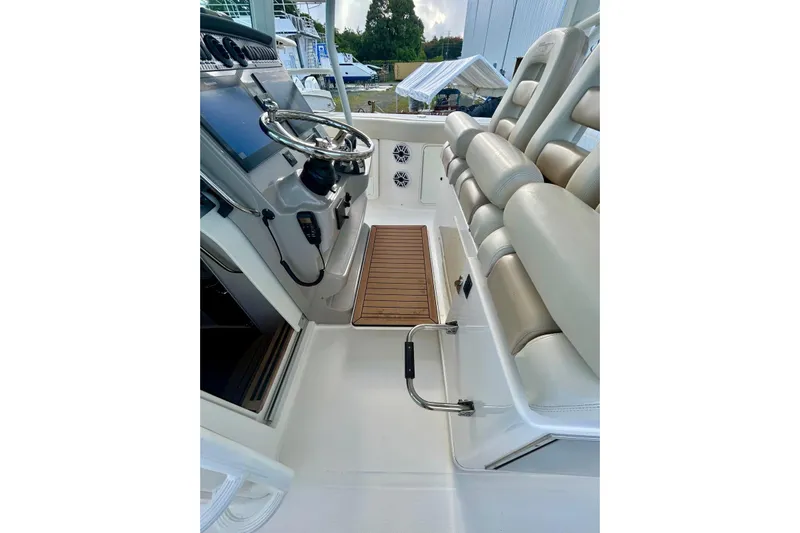  Yacht Photos Pics 2017 Boston Whaler 380 Outrage helm with steering wheel and cushioned seating.