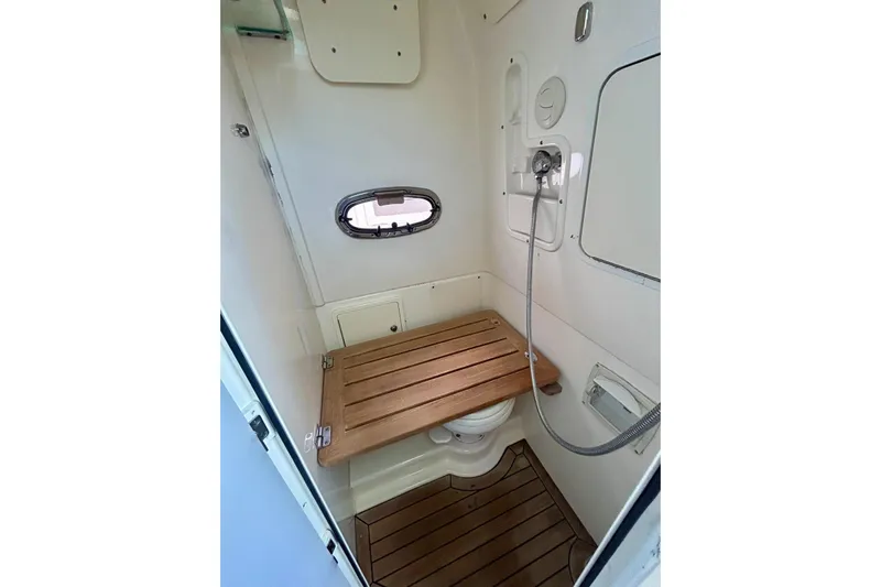  Yacht Photos Pics 2017 Boston Whaler 380 Outrage bathroom with wooden seat and showerhead.