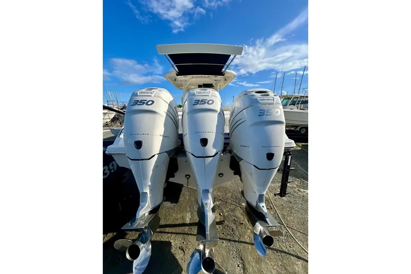  Yacht Photos Pics 2017 Boston Whaler 380 Outrage with triple 350 horsepower engines, docked under blue sky.