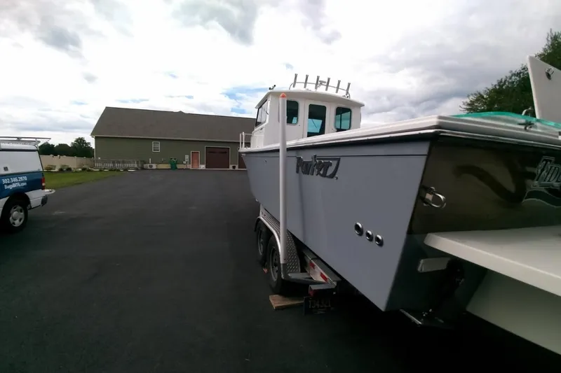  Yacht Photos Pics 2024 Parker 2820 XLD Sport Cabin boat on trailer in driveway, overcast sky.