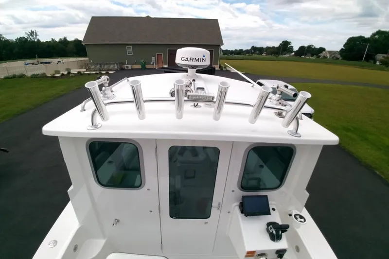  Yacht Photos Pics 2024 Parker 2820 XLD Sport Cabin boat with Garmin radar, docked in a residential area.
