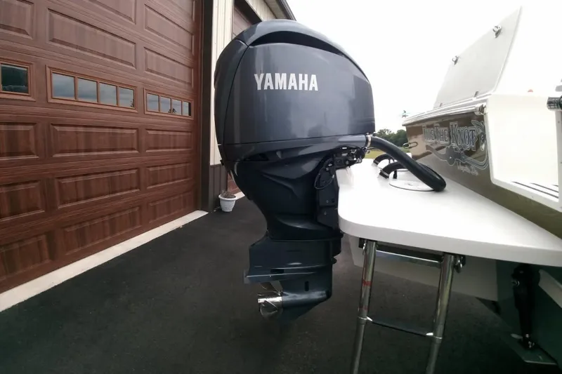  Yacht Photos Pics 2024 Parker 2820 XLD Sport Cabin with Yamaha outboard motor, parked near a garage.