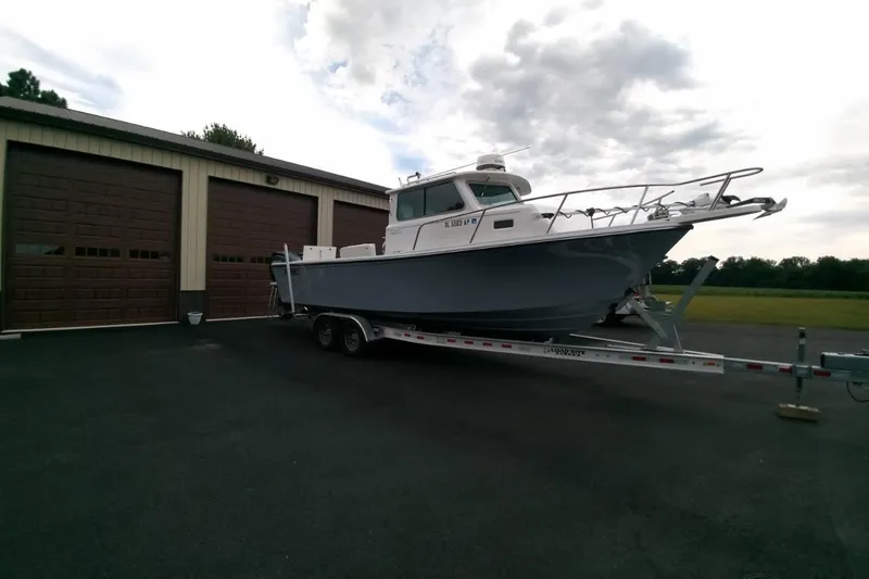  Yacht Photos Pics 2024 Parker 2820 XLD Sport Cabin boat on trailer near garage.