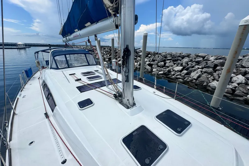  Yacht Photos Pics Beneteau Oceanis 50 sailboat, 2011 model, docked by rocky shoreline under cloudy sky.
