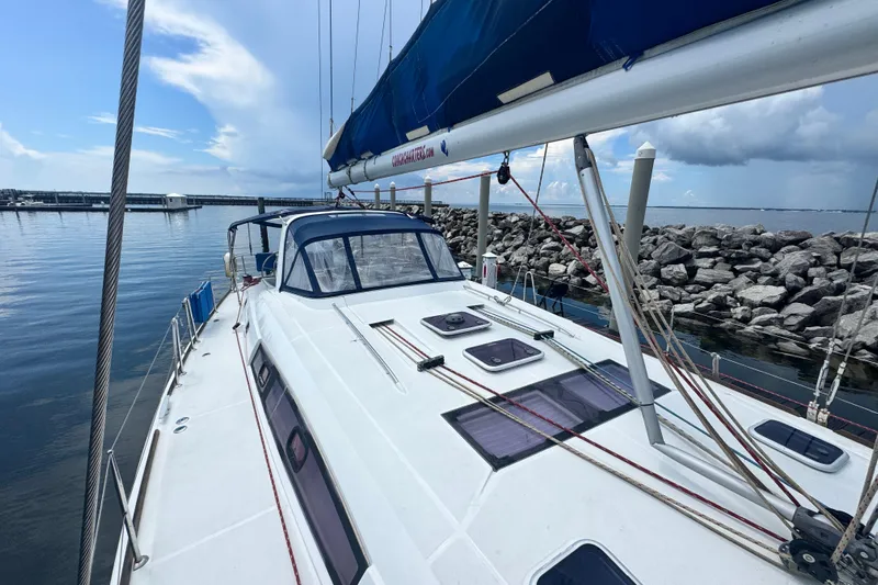  Yacht Photos Pics 2011 Beneteau Oceanis 50 sailboat docked by rocky shoreline under blue sky.