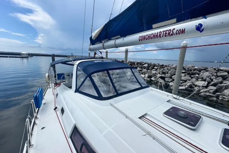  Yacht Photos Pics 2011 Beneteau Oceanis 50 sailboat docked by rocky shoreline under cloudy sky.