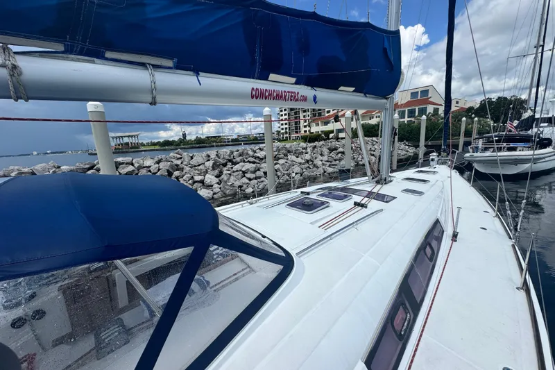  Yacht Photos Pics 2011 Beneteau Oceanis 50 sailboat docked near rocky shoreline under cloudy sky.