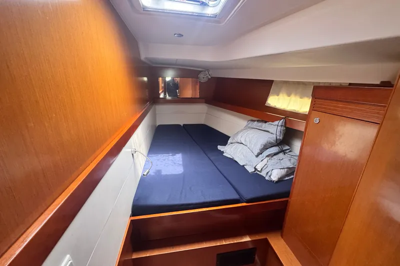  Yacht Photos Pics Cozy cabin interior of 2011 Beneteau Oceanis 50 yacht with wooden finish and bedding.