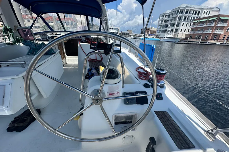  Yacht Photos Pics Cockpit of 2011 Beneteau Oceanis 50 sailboat with steering wheel and marina view.