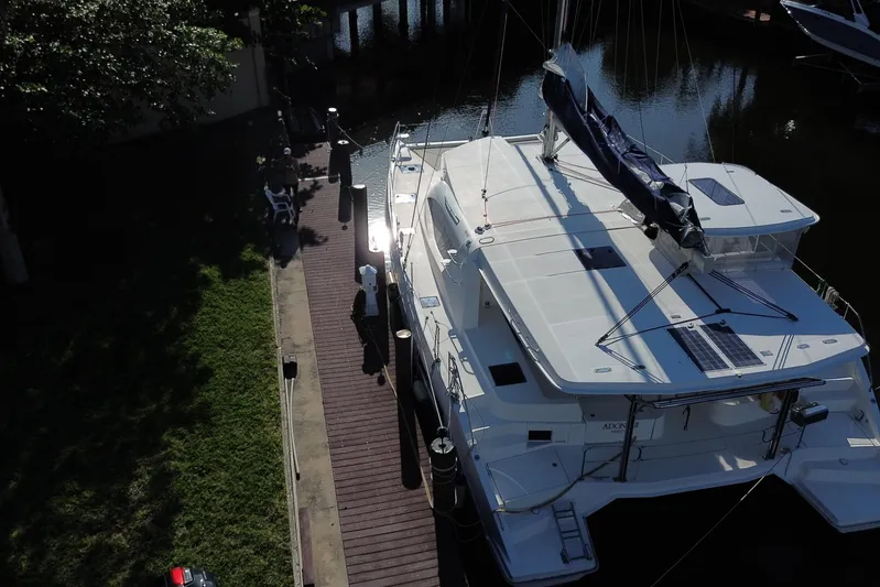 Adonis II Yacht Photos Pics Aerial view of 2017 Leopard 48 catamaran docked by a wooden pier.
