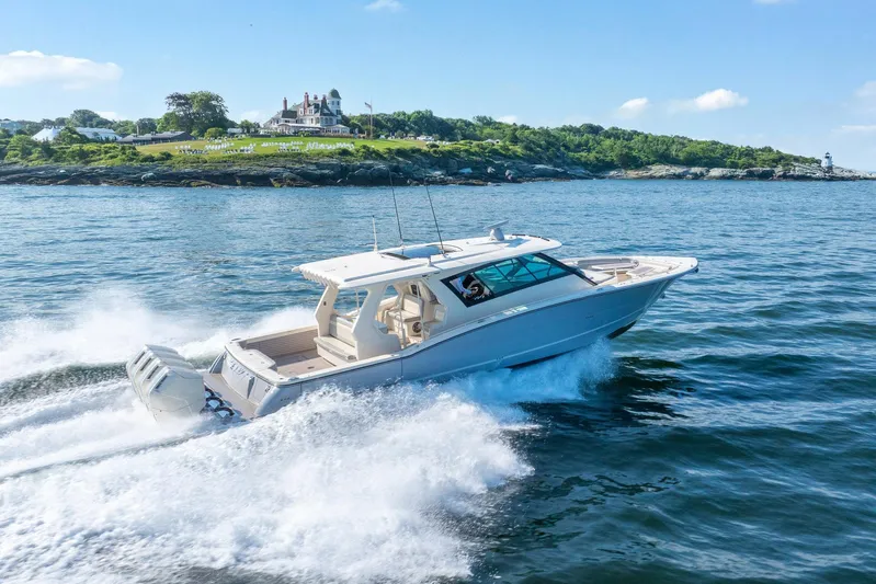 Dealership II Yacht Photos Pics 2023 Scout 530 LXF cruising on ocean near scenic coastline.