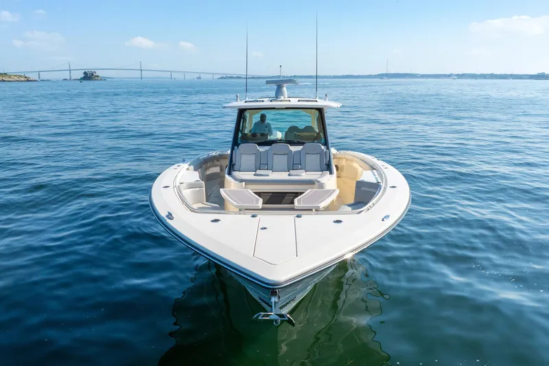Dealership II Yacht Photos Pics 2023 Scout 530 LXF luxury boat on calm blue water, clear sky background.