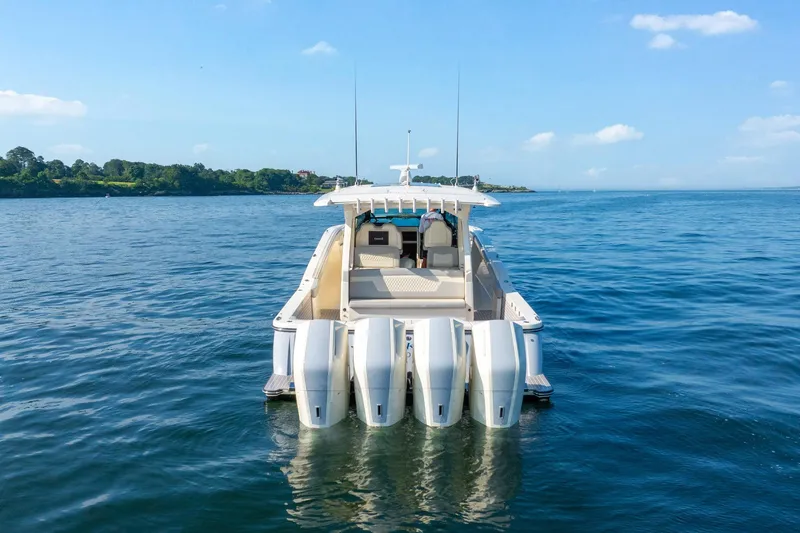 Dealership II Yacht Photos Pics 2023 Scout 530 LXF boat on calm water, rear view with four engines.