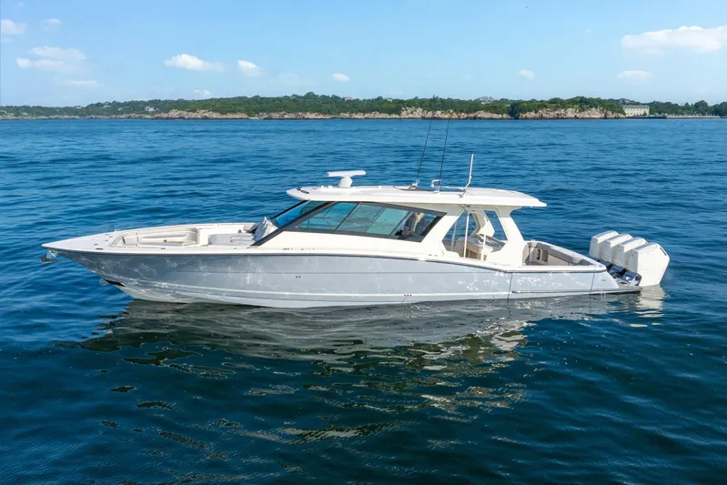 Dealership II Yacht Photos Pics 2023 Scout 530 LXF luxury boat on calm blue water, clear sky background.