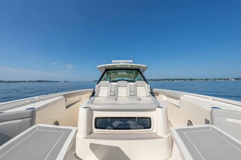 Dealership II Yacht Photos Pics 2023 Scout 530 LXF luxury boat on calm water under clear blue sky.