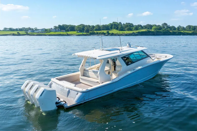 Dealership II Yacht Photos Pics 2023 Scout 530 LXF luxury boat cruising on a serene lake.