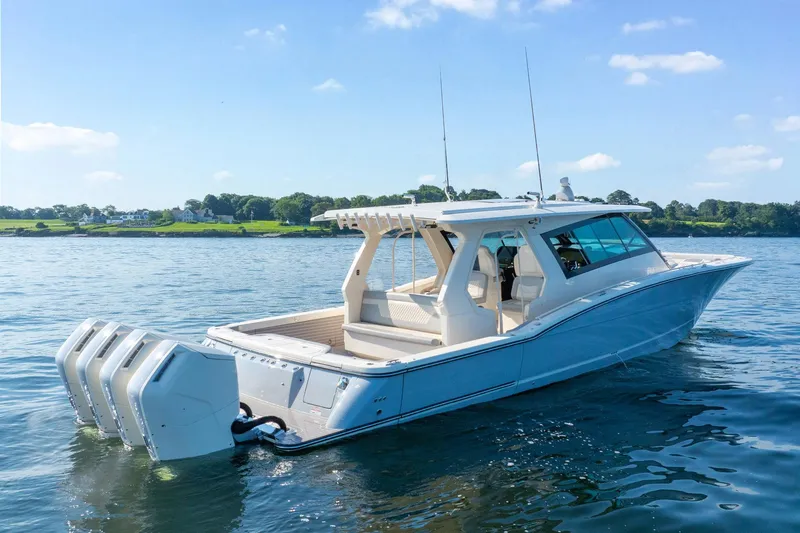 Dealership II Yacht Photos Pics 2023 Scout 530 LXF luxury boat on calm water, showcasing sleek design and powerful engines.