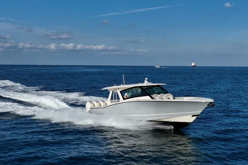 Dealership II Yacht Photos Pics 2023 Scout 530 LXF cruising on open ocean under clear blue sky.