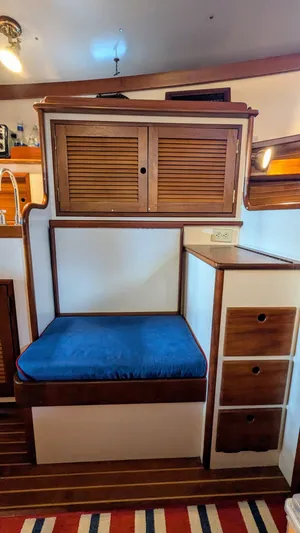 Safari Yacht Photos Pics Interior of 1990 Stanley Downeast Lobster Yacht with blue cushioned seating and wooden cabinetry.