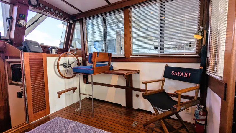 Safari Yacht Photos Pics 1990 Stanley Downeast Lobster Boat interior with wooden helm, seating, and "Safari" chair.