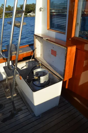 Safari Yacht Photos Pics 1990 Stanley Downeast Lobster Boat with open storage compartment on deck, near water.