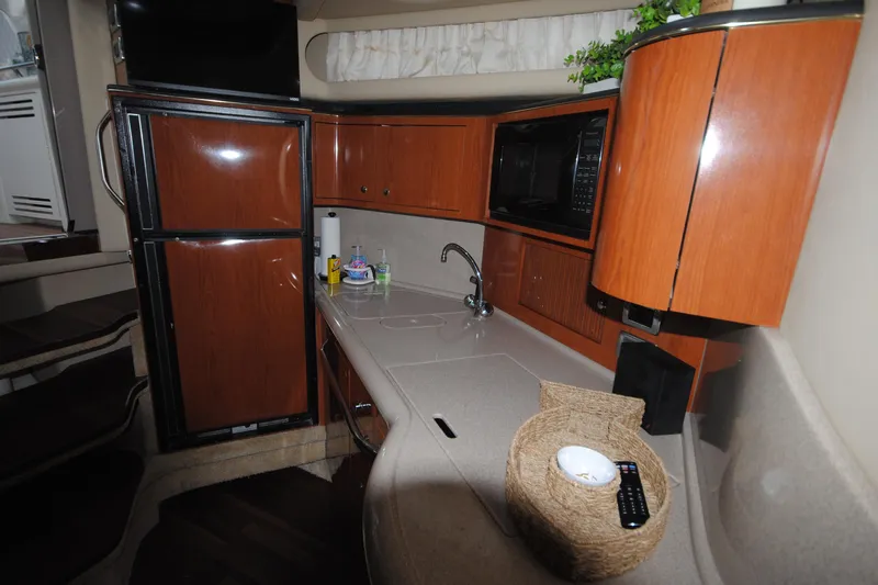  Yacht Photos Pics 2002 Sea Ray 380 Sundancer yacht interior with kitchenette, featuring wood cabinetry and modern appliances.