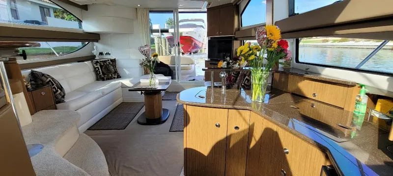 Panache Yacht Photos Pics Luxurious interior of a 2016 Meridian 391 Sedan yacht with elegant furnishings and floral decor.