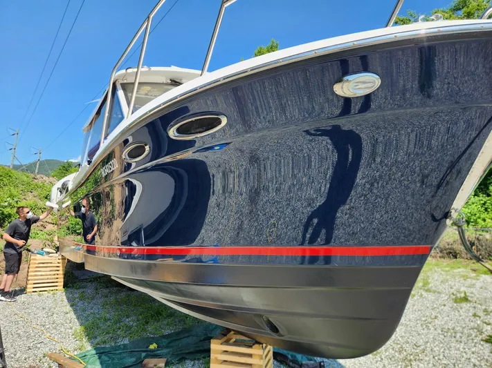  Yacht Photos Pics 2019 Cutwater C-28 boat on land, with people inspecting its hull.