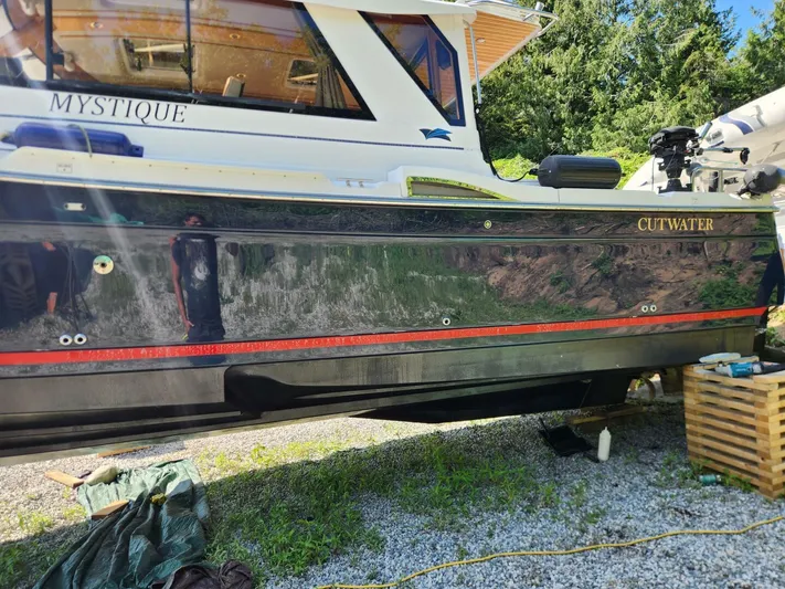  Yacht Photos Pics 2019 Cutwater C-28 boat named Mystique on land, surrounded by greenery.