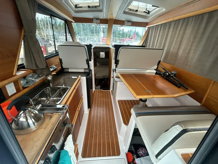  Yacht Photos Pics 2019 Cutwater C-28 boat interior with kitchenette, dining area, and wood accents.