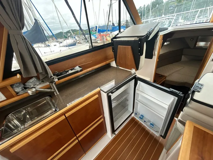  Yacht Photos Pics Interior of a 2019 Cutwater C-28 boat with kitchenette and open fridge.