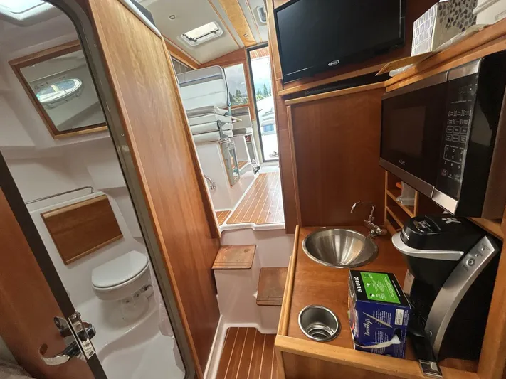  Yacht Photos Pics 2019 Cutwater C-28 interior with kitchenette, sink, microwave, and compact bathroom.