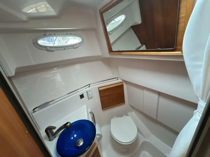  Yacht Photos Pics 2019 Cutwater C-28 boat bathroom with blue sink, toilet, and mirror.