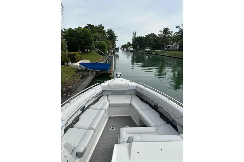 Oceanholic Yacht Photos Pics 2018 Formula 330 Crossover Bowrider on a serene canal with lush greenery.