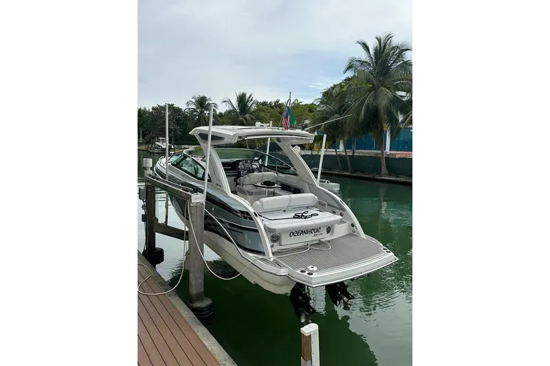 Oceanholic Yacht Photos Pics 2018 Formula 330 Crossover Bowrider docked by palm trees, rear view.