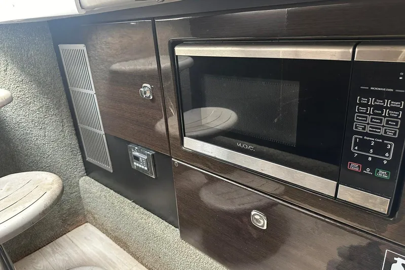 Oceanholic Yacht Photos Pics 2018 Formula 330 Crossover Bowrider interior with microwave and dark cabinetry.