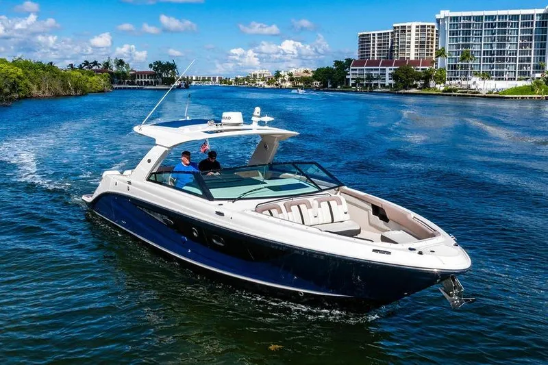Sobe III Yacht Photos Pics 2019 Sea Ray SLX 400 Outboard cruising on a scenic waterway with modern buildings.