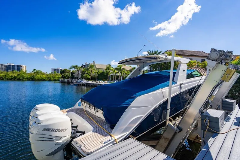 Sobe III Yacht Photos Pics 2019 Sea Ray SLX 400 Outboard docked, covered, with Mercury engines, under clear blue sky.