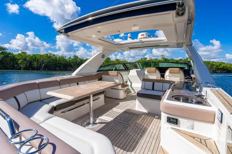 Sobe III Yacht Photos Pics 2019 Sea Ray SLX 400 Outboard luxury boat interior with seating and table, under blue sky.