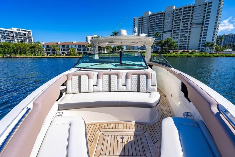 Sobe III Yacht Photos Pics 2019 Sea Ray SLX 400 Outboard boat with luxurious seating, docked near waterfront buildings.