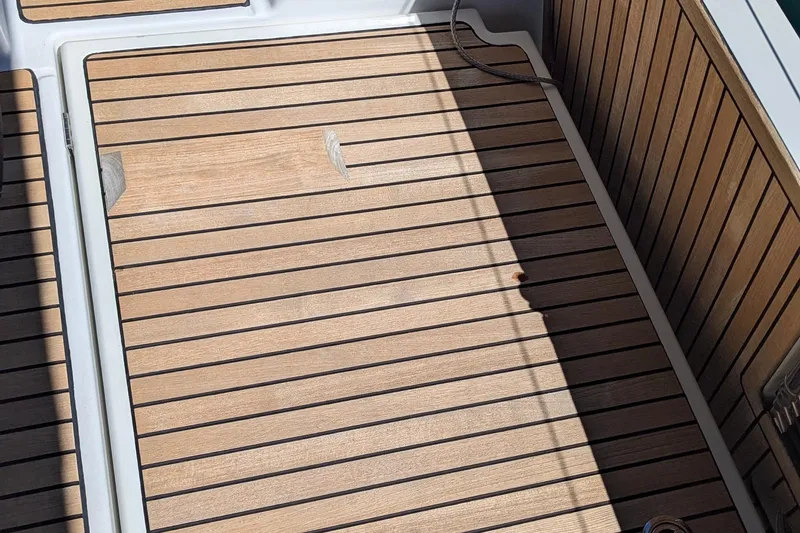 Her Intentions Yacht Photos Pics Teak deck of 2021 Jeanneau Sun Odyssey 440 sailboat, featuring sleek wood paneling.