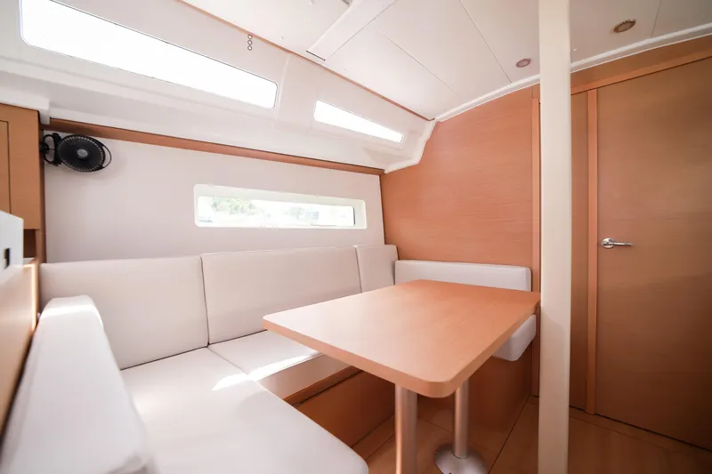 Twenty One Cent Yacht Photos Pics Interior of 2022 Jeanneau Sun Odyssey 380, featuring a cozy dining area with natural light.