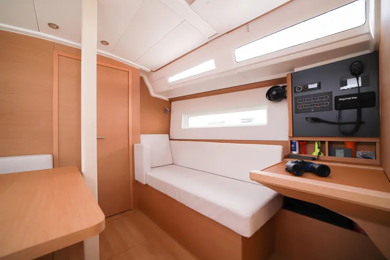 Twenty One Cent Yacht Photos Pics Interior of 2022 Jeanneau Sun Odyssey 380 sailboat, featuring modern navigation equipment and cozy seating.