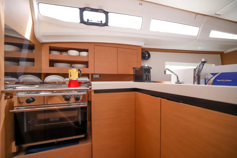 Twenty One Cent Yacht Photos Pics Modern kitchen interior of 2022 Jeanneau Sun Odyssey 380 yacht, featuring sleek cabinetry and appliances.
