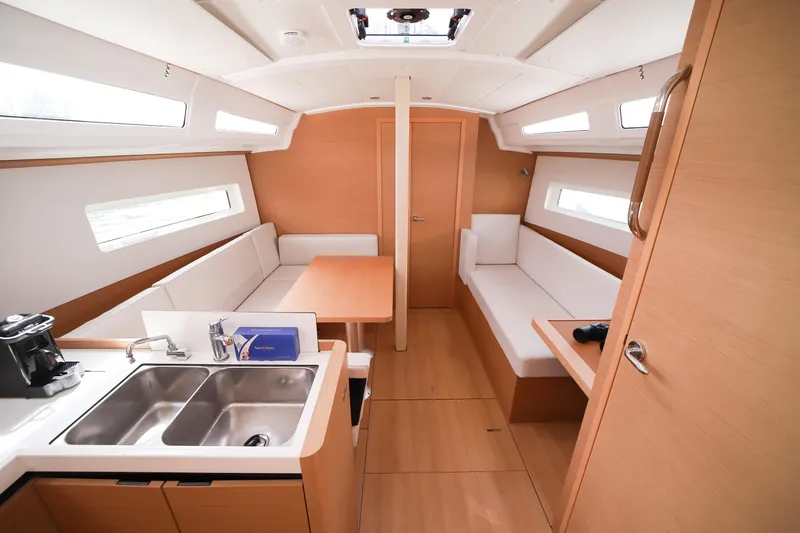 Twenty One Cent Yacht Photos Pics Interior of 2022 Jeanneau Sun Odyssey 380 yacht, featuring modern kitchen and seating area.