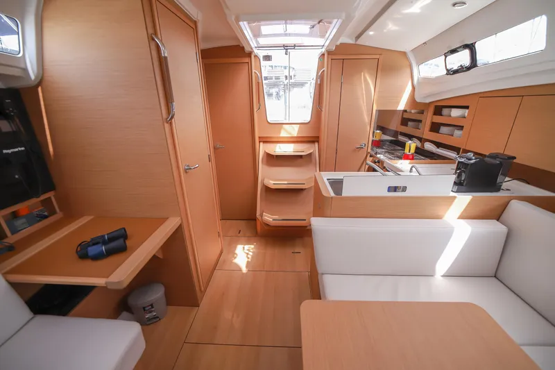 Twenty One Cent Yacht Photos Pics Interior of 2022 Jeanneau Sun Odyssey 380 sailboat, featuring modern wood finish and compact kitchen.