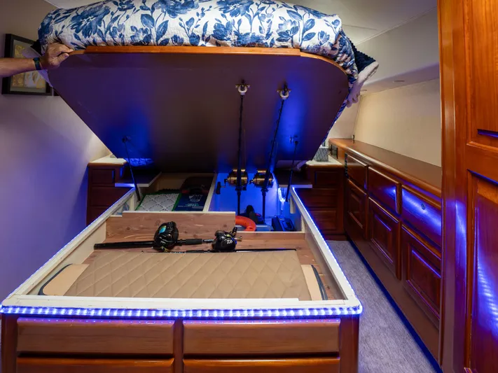 Samurai Yacht Photos Pics Under-bed storage in 1998 Viking 58 Convertible yacht, featuring fishing gear and blue LED lighting.