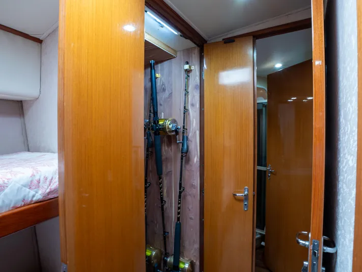 Samurai Yacht Photos Pics 1998 Viking 58 Convertible interior with fishing rods and wooden cabinetry.