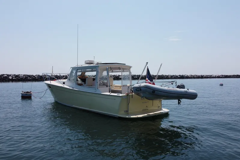 Tango Yacht Photos Pics 2006 MJM 34z Downeast boat anchored in calm waters with a dinghy attached.