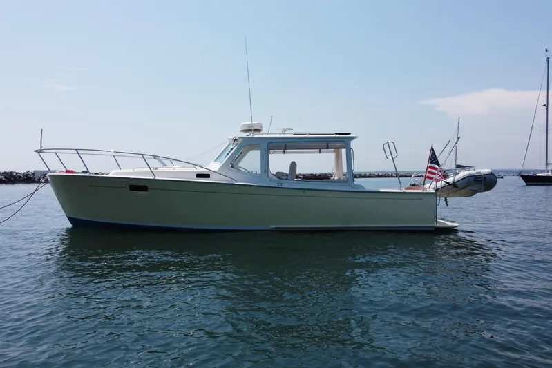 Tango Yacht Photos Pics 2006 MJM 34z Downeast boat on calm water with American flag.